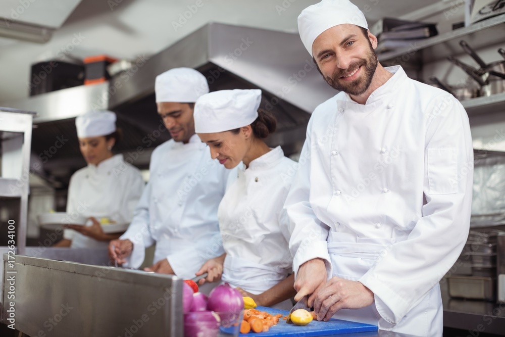 Chefs chopping vegetables on chopping board in the commercial Chefs chopping vegetables on chopping board in the commercial
