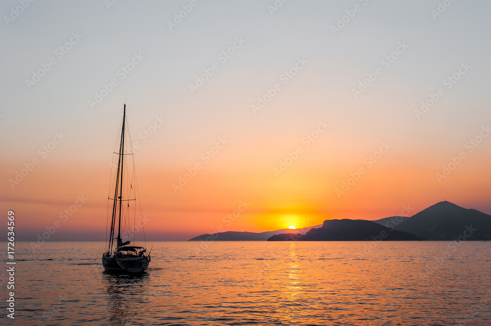 Tranquil nature scene of sailing boat in the ocean at sunset 