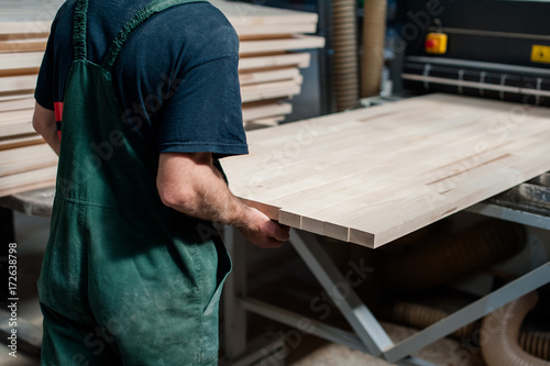 Man worker holding a big countertop in a furniture manufacture production.