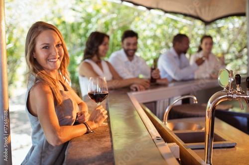 Portrait of smiling woman having a glass of red wine at counter