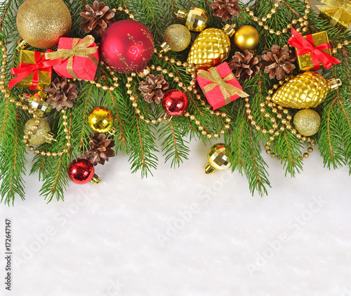 Christmas decorations on a spruce branch on a white