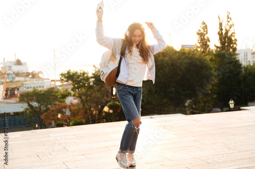 Full length image of happy brunette woman in autumn clothes