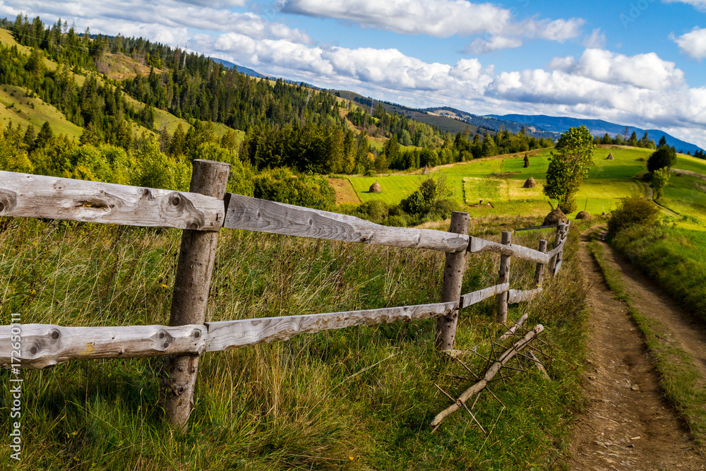 Old wooden fence near the mountain road in the Carpathians