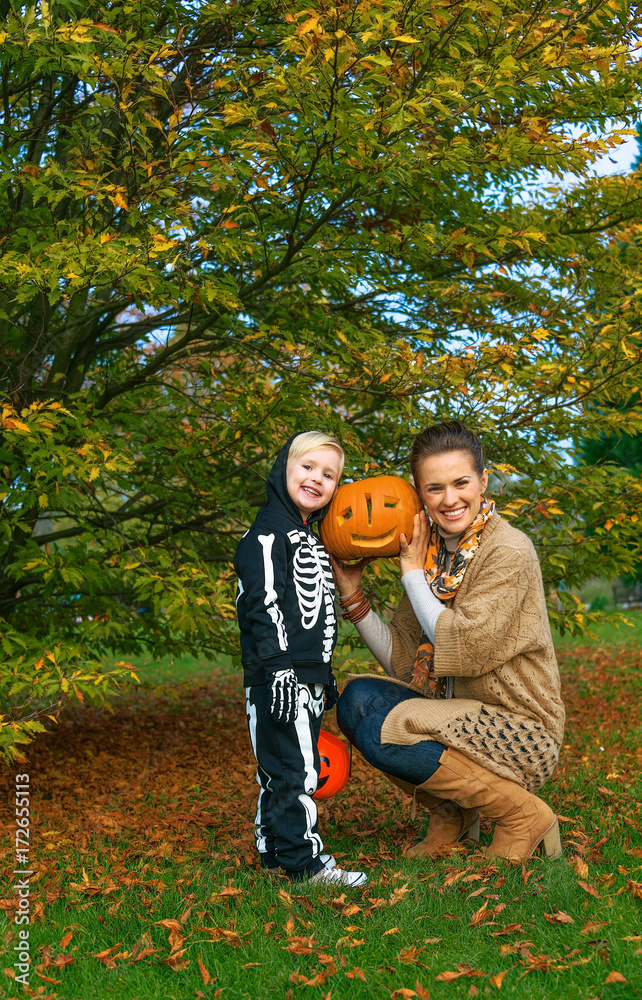 Fototapeta premium mother and daughter showing carved Halloween pumpkin