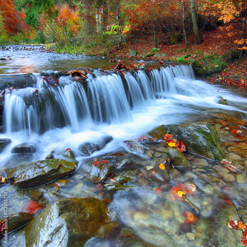 Mountain river with rapids and waterfalls at autumn time
