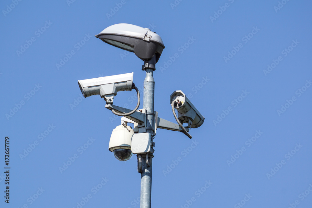 security cctv cameras on a pole with blue sky background security cctv cameras on a pole with blue sky background