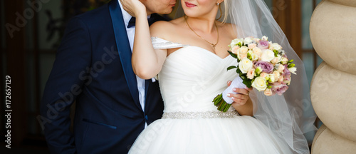 Wedding. Wedding day. Beautiful bride and elegant groom walking after wedding ceremony. Luxury bridal dress and bouquet of flowers. Bride and groom at wedding day photo