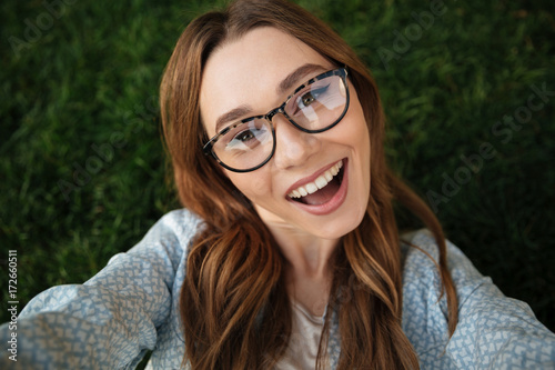 Close up top view of joyful brunette woman in eyeglasses