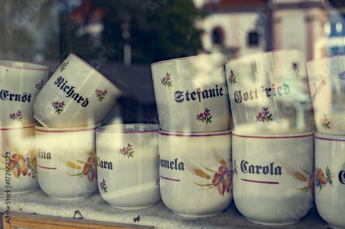 Coffee mugs behind a shop window.
