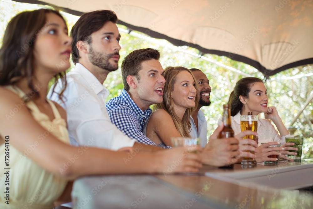 Obraz premium Friends watching football match at counter