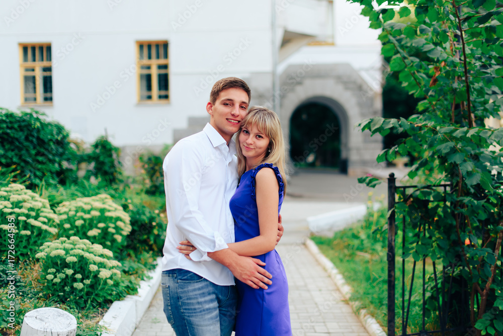 loving young couple walking around town man in white shirt and girl in blue dress