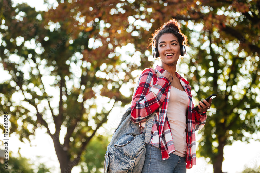 Cheerful young african woman walking outdoors Cheerful young african woman walking outdoors