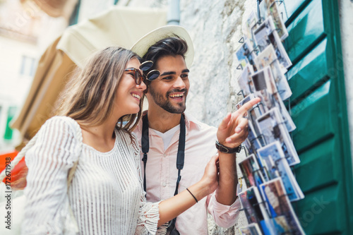 Tourist couple enjoying sightseeing  exploring city and buy postcards photo