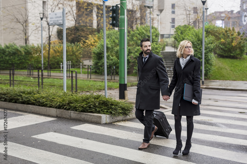 Business couple in the city crossing a street Business couple in the city crossing a street