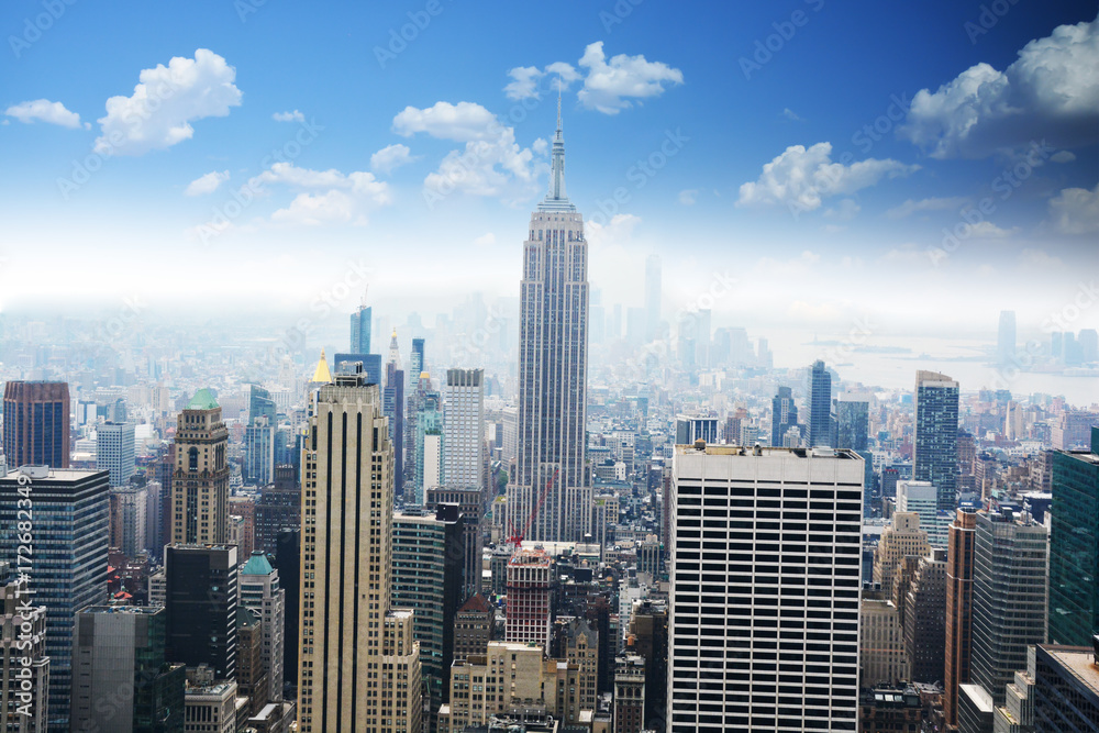 Aerial view of Empire State Building, looking over midtown Manhattan, with clear blue sky