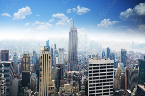 Aerial view of Empire State Building  looking over midtown Manhattan  with clear blue sky