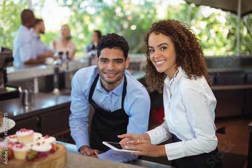 Male waiter and female waitress with digital tablet photo