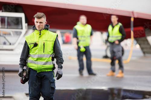 Confident Ground Staff Member Standing On Airport Runway