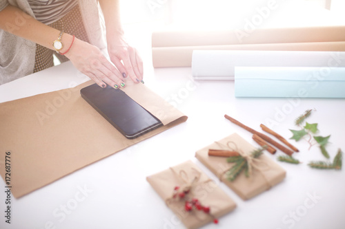 Hands of woman decorating christmas gift box. Hands of woman