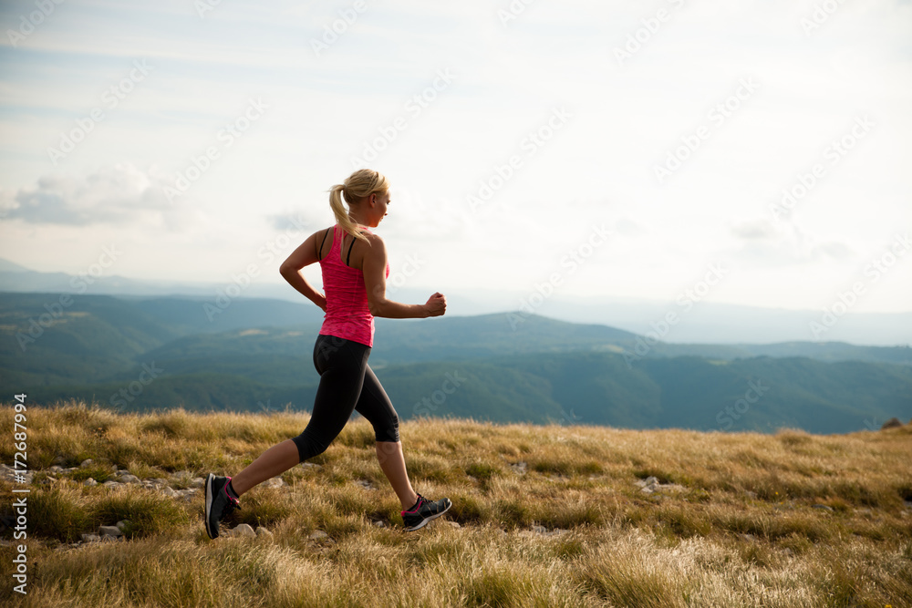runner - woman runs cros country on a path in early autumn runner - woman runs cros country on a path in early autumn