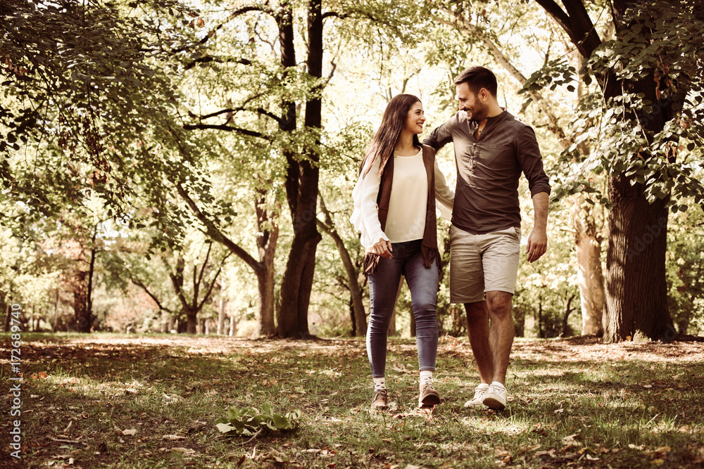 Young couple enjoying together in park. Loving couple in nature. Young couple enjoying together in park. Loving couple in nature.