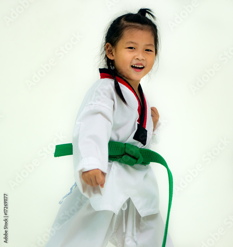 Asian girl wearing white Taekwondo suit acting ready to battle, On white background. photo