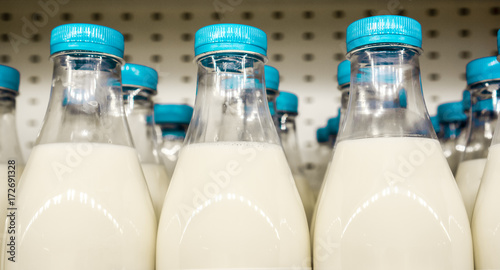 bottles with milk as dairy product for preparing breakfast wait for byers on market shelf