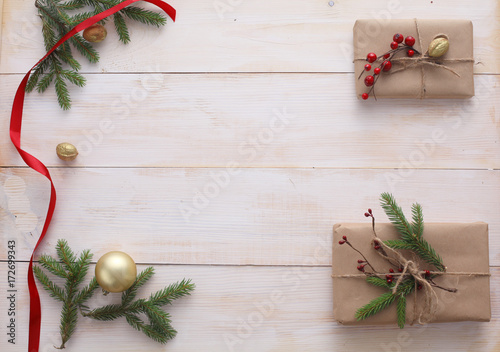 Christmas gift boxes and fir tree branch on wooden table, flat lay. Сhristmas background