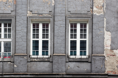 The shabby facade of the grey house.