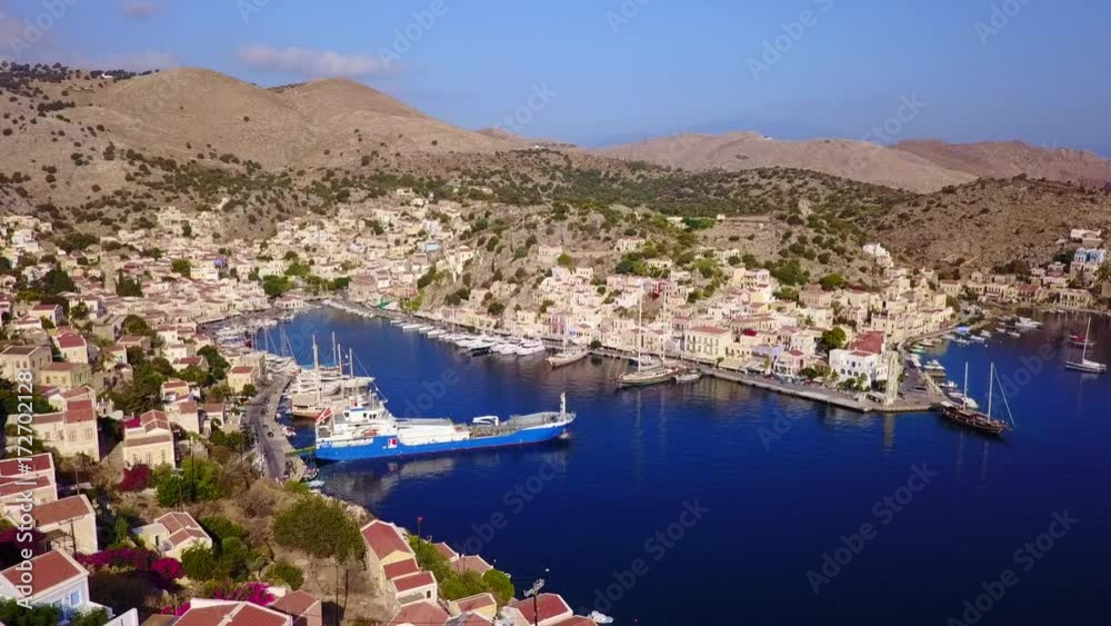 August 2017: Aerial drone video of picturesque port of Symi island with colourful neoclassic houses, Dodecanese, Aegean, Greece August 2017: Aerial drone video of picturesque port of Symi island with colourful neoclassic houses, Dodecanese, Aegean, Greece