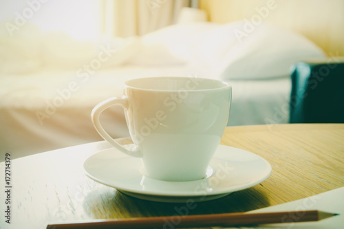 Hot cup of coffee on wooden table in bedroom fresh morning concept