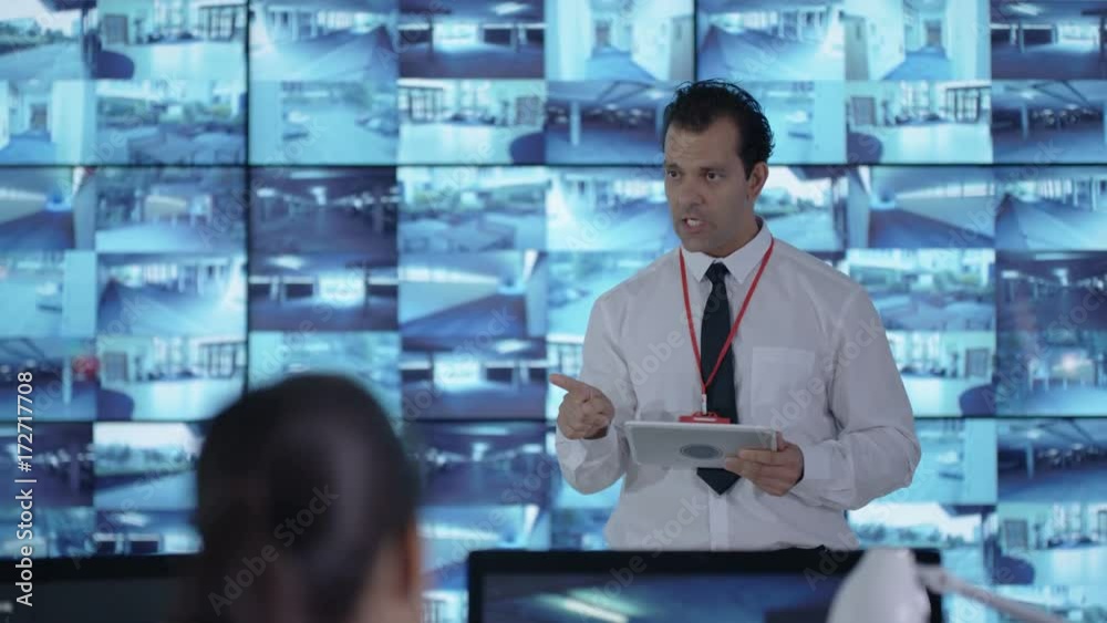 Security officer communicating with staff in observation control room Security officer communicating with staff in observation control room