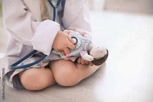 Little girl in medical coat...