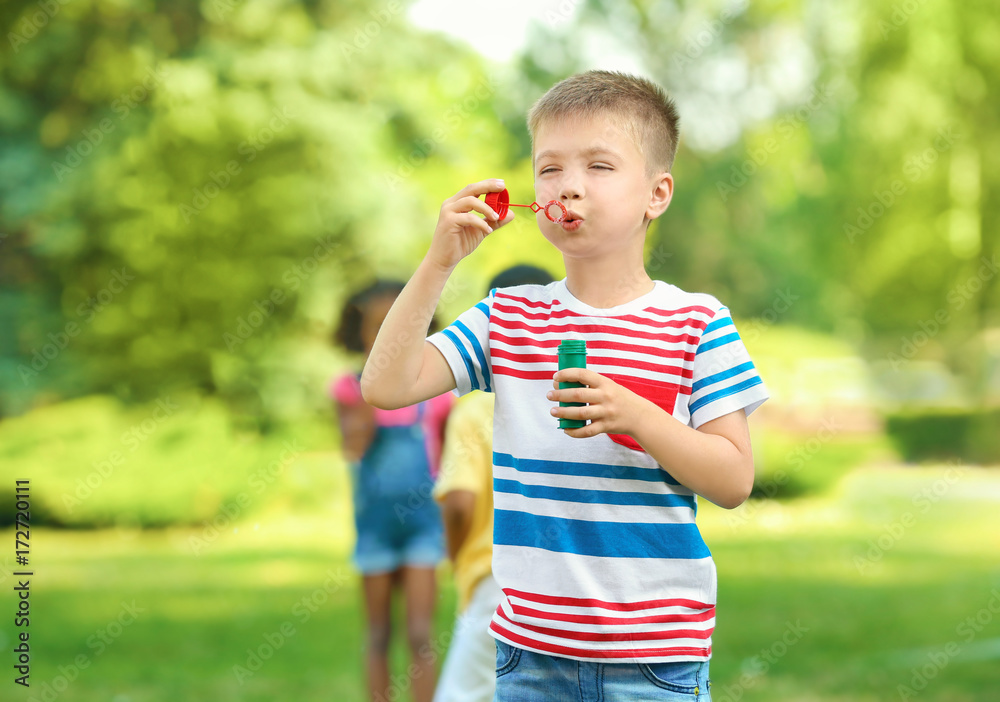Cute little boy blowing soap bubbles outdoors Cute little boy blowing soap bubbles outdoors