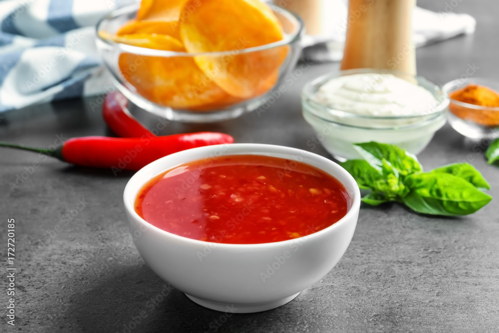 Ceramic bowl with chili sauce on kitchen table Ceramic bowl with chili sauce on kitchen table