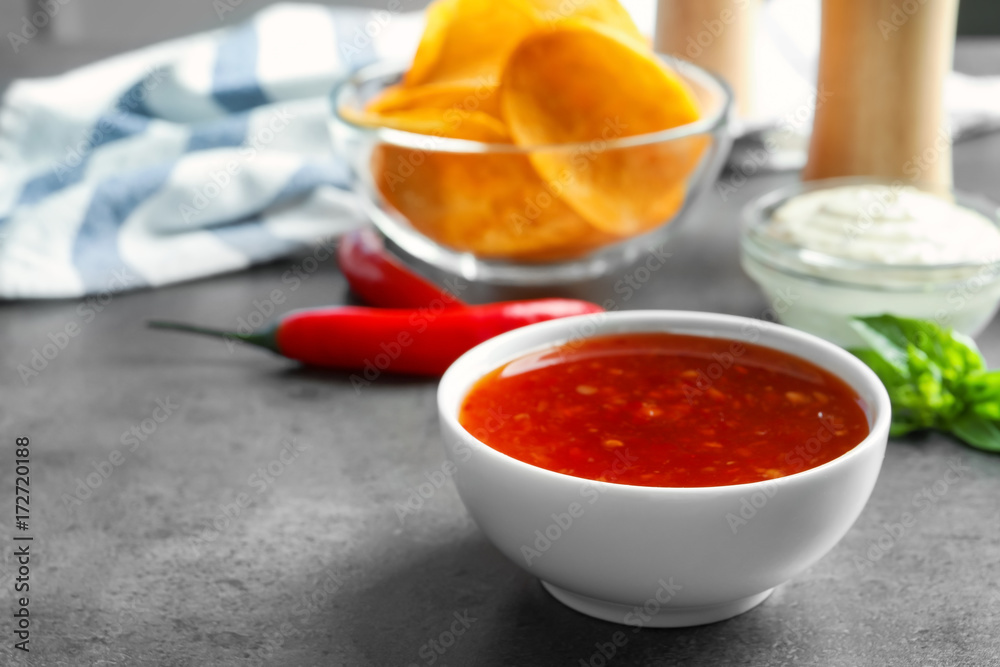 Ceramic bowl with chili sauce on kitchen table Ceramic bowl with chili sauce on kitchen table