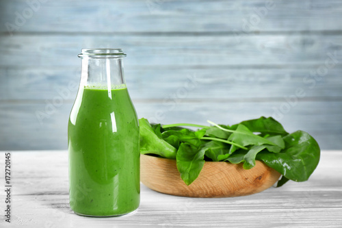 Bottle of spinach smoothie on table