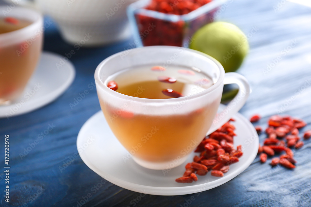 Cup with goji tea on table Cup with goji tea on table
