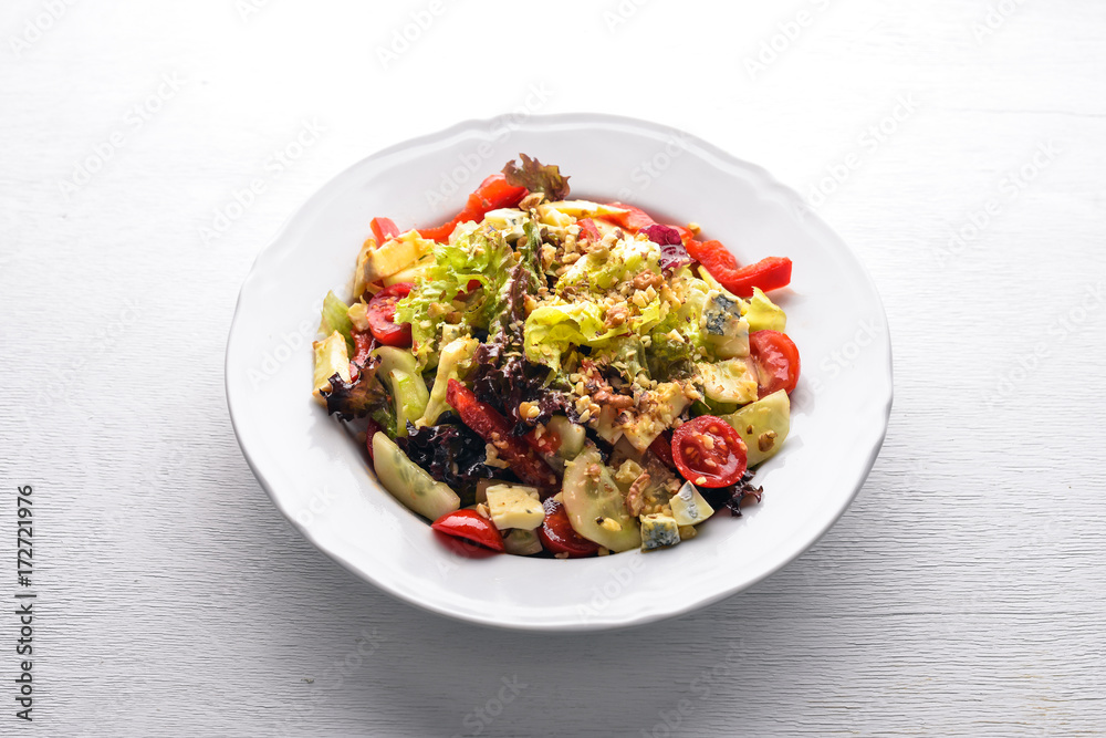 Salad of fresh vegetables and gorgonzola cheese. On a wooden background. Top view. Free space.