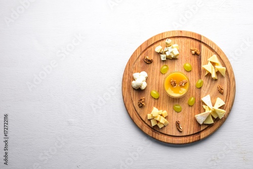 Assorted cheeses, gorgonzola, brie, feta, with honey. On a wooden background. Top view. Free space.