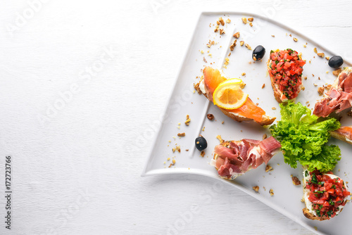 Bruschetta Sandwich with salmon and hamoon. On a wooden background. Top view. Free space.