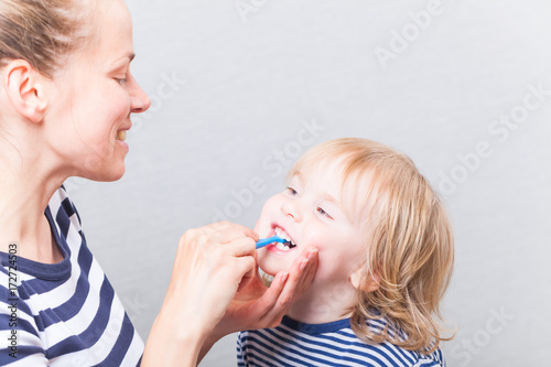 Mom with baby brushing teeth