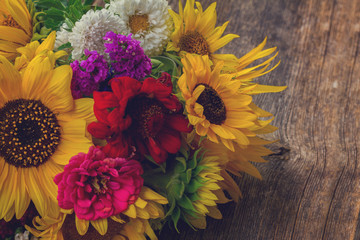 Bright bunch of fresh fall flowers on wooden table, retro toned