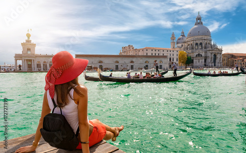 Attraktive Touristin am Canal Grande in Venedig schaut auf die Basilica Santa Maria della Salute