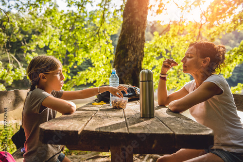 Mother and daughter eating at a picnic table photo