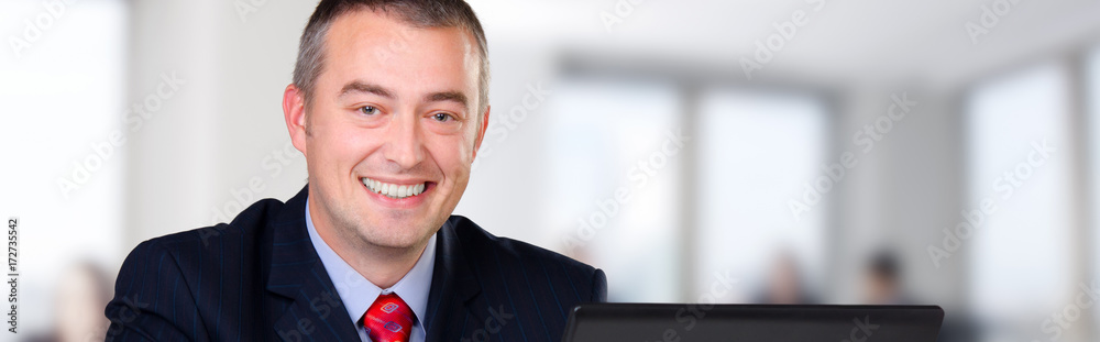 Young happy businessman working in his office Young happy businessman working in his office