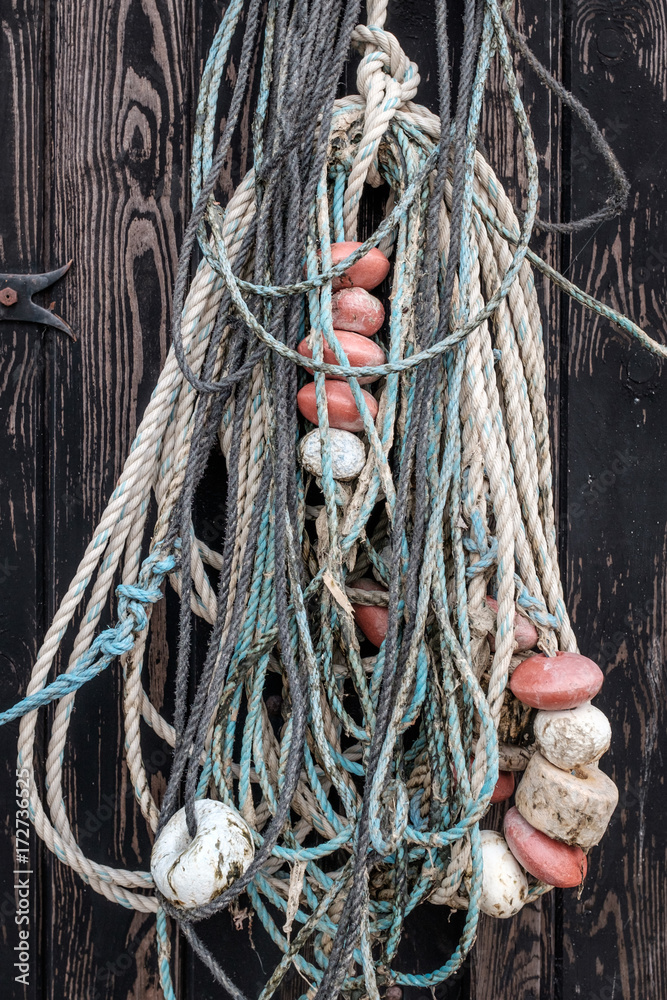 An old fishing net hanging on rustic wooden wall