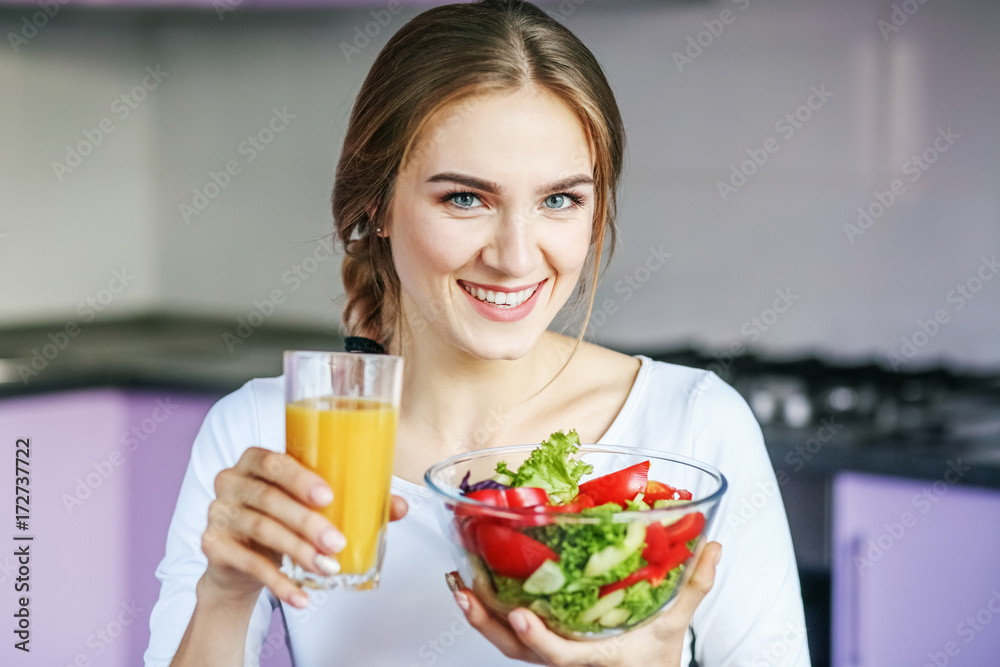 Young woman eating vegetable salad in the kitchen. The concept is healthy food, diet, vegetarianism, weight loss. Young woman eating vegetable salad in the kitchen. The concept is healthy food, diet, vegetarianism, weight loss.