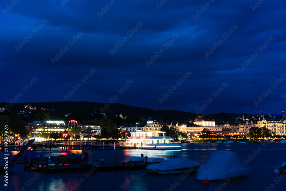 big cruise boat on lake zurich at night with blue water and lights