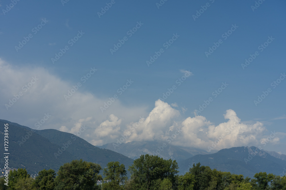 Naklejka premium lago maggiore lake scenery with mountain water and cloudy sky